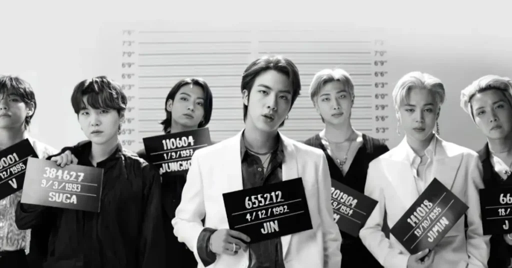 BTS members holding mugshot signs from the Butter music video, representing the global most viewed song in the first 24 hours on YouTube of all time